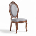 Wooden dining chair with light gray upholstered seat and ornate design