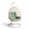 Hanging egg chair with removable cushion in green color and metal stand